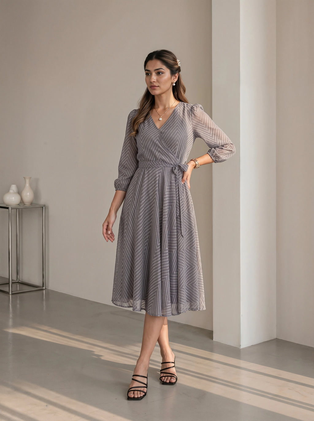Woman wearing a gray patterned dress in an indoor setting