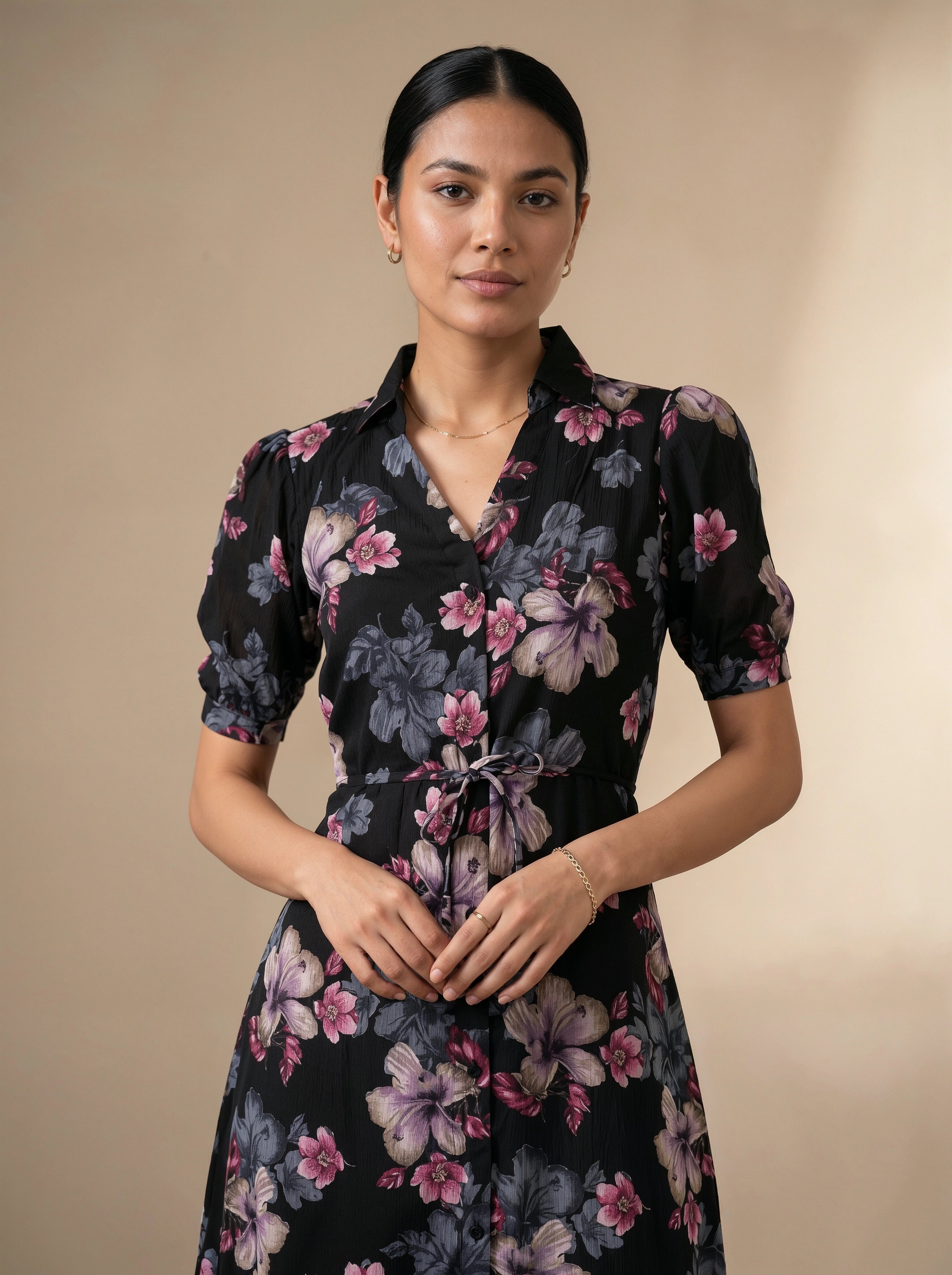 Woman wearing a black floral dress against a beige background