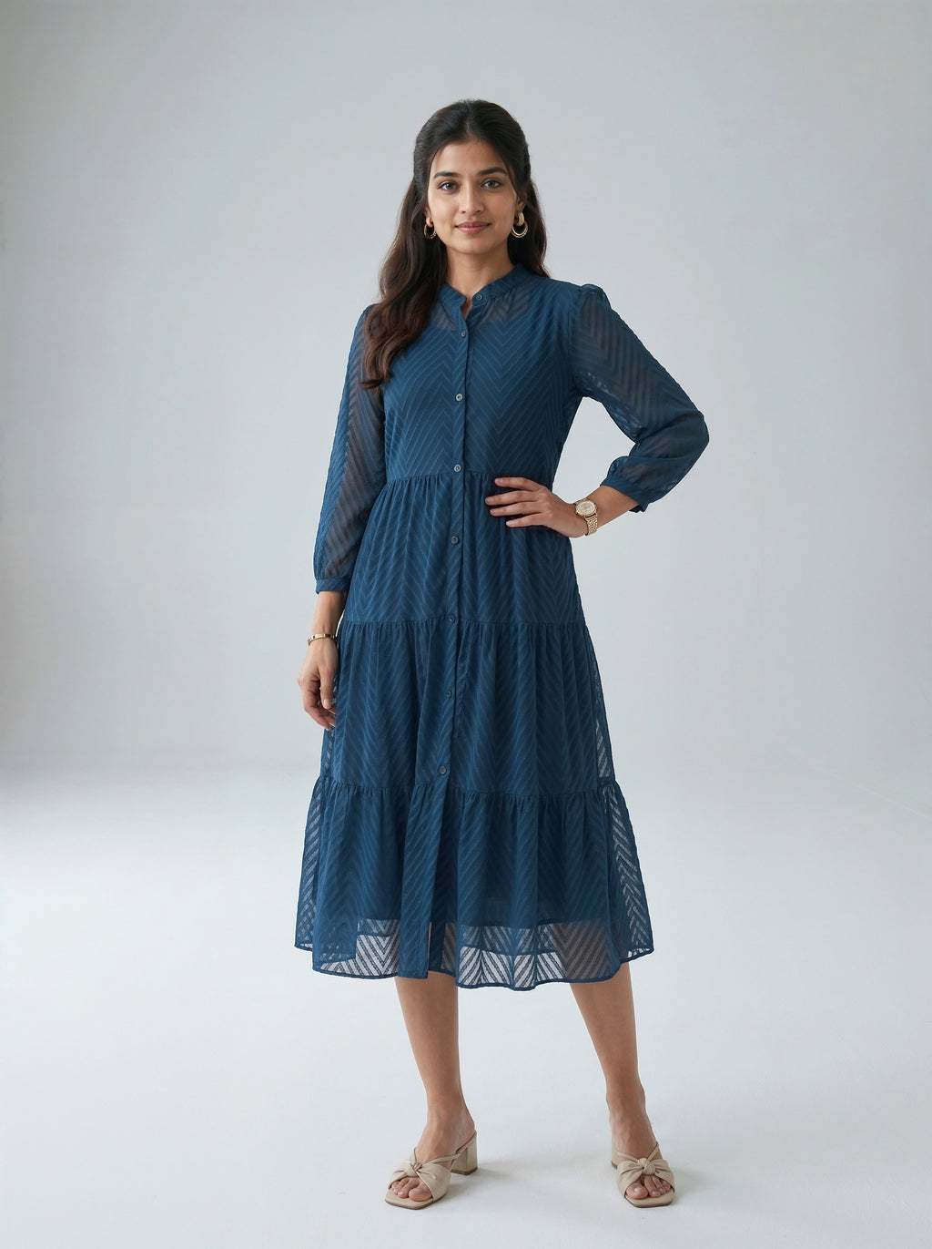 Woman wearing a blue dress with long sleeves on a white background