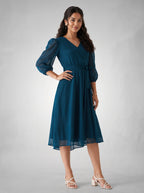 Woman wearing a blue dress against a gray background