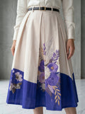 Beige skirt with floral patterns and a blue bottom section worn by a person.