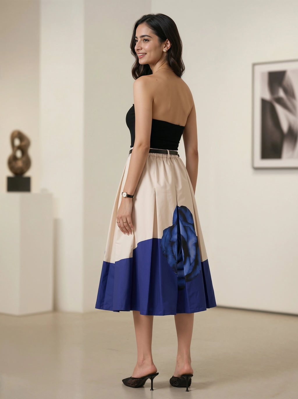 Woman wearing a black, beige, and blue dress in an indoor setting.