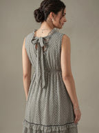 Woman wearing a patterned dress with a neutral background