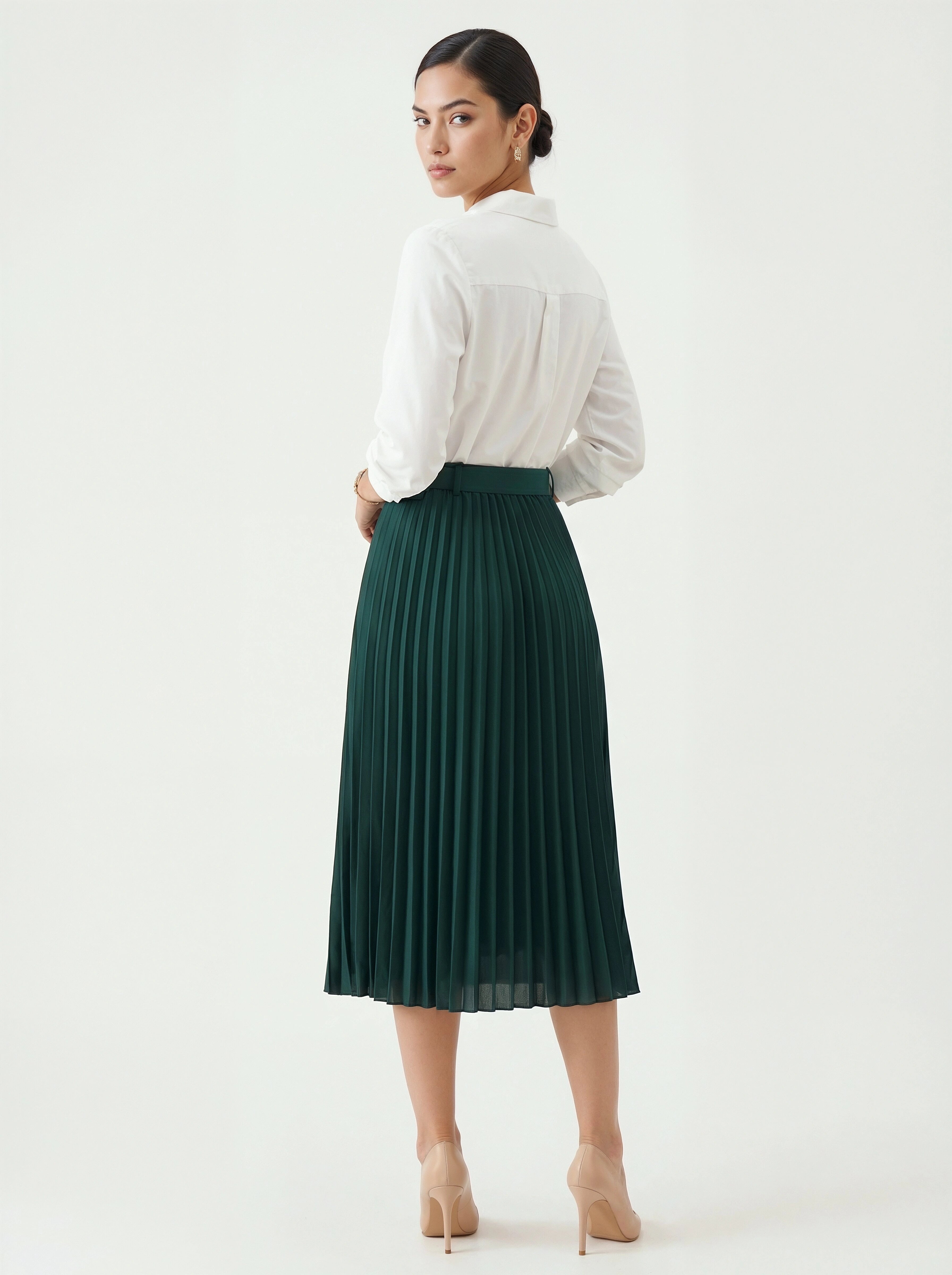 Woman wearing a white blouse and green pleated skirt on a white background