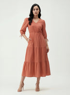 Woman wearing a rust-colored dress on a white background