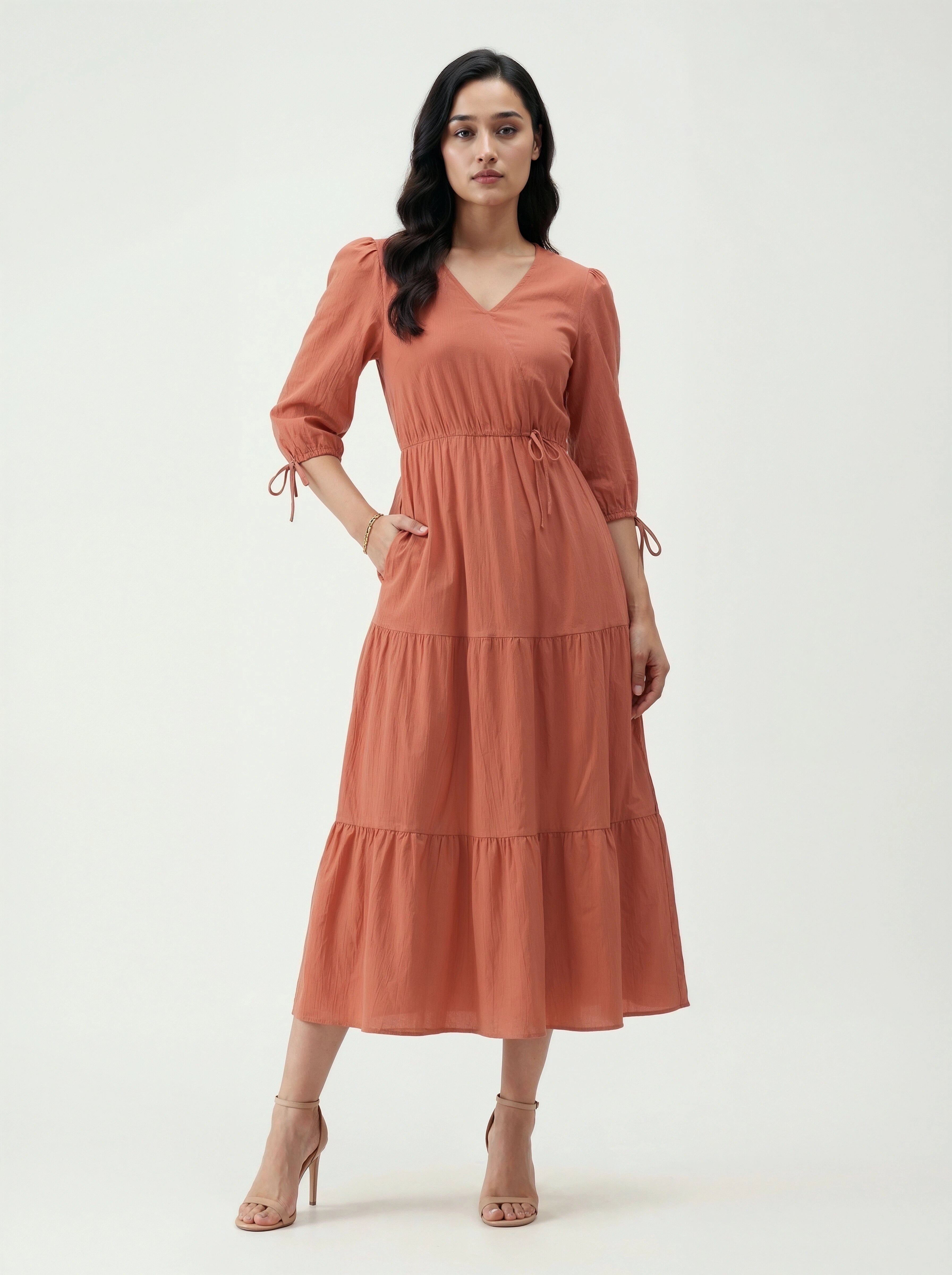 Woman wearing a rust-colored dress on a white background