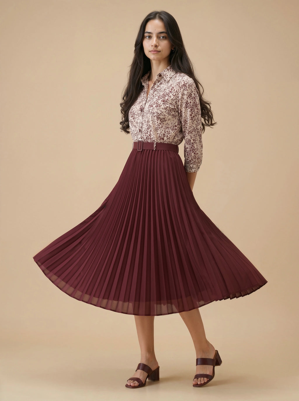 Woman wearing a floral blouse and pleated skirt on a beige background