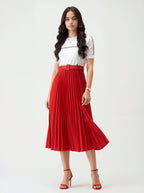 Woman wearing a white top and red pleated skirt on a white background