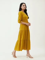 Woman wearing a mustard yellow dress on a white background