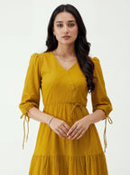 Woman wearing a mustard yellow dress on a white background
