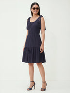 Woman wearing a navy blue dress on a white background