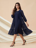 Woman wearing a navy blue dress with a matching jacket on a beige background