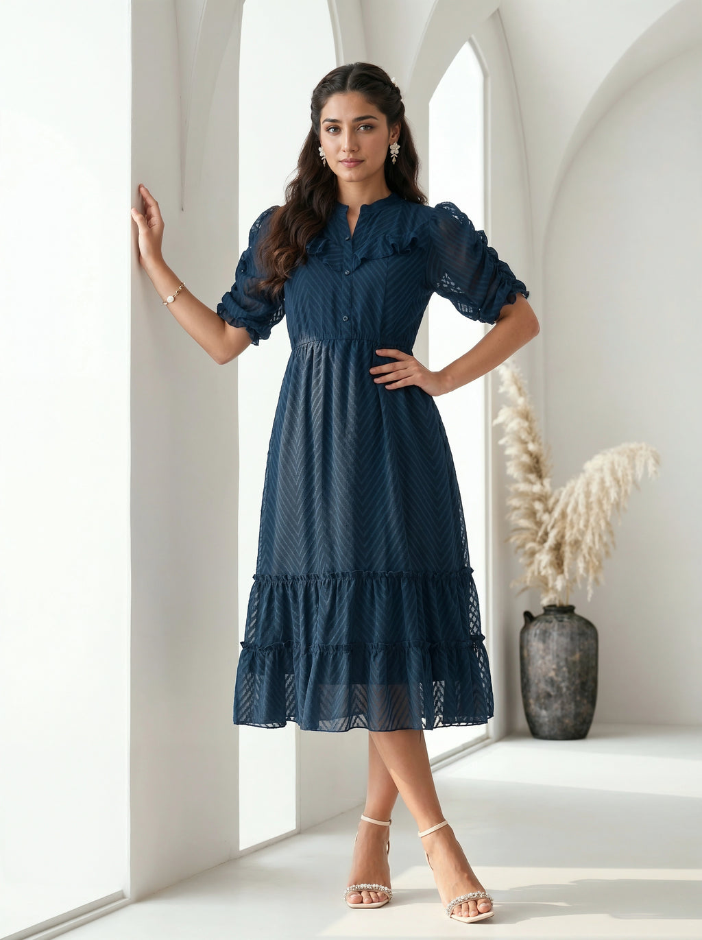 Woman wearing a gray dress with a textured pattern against a plain background