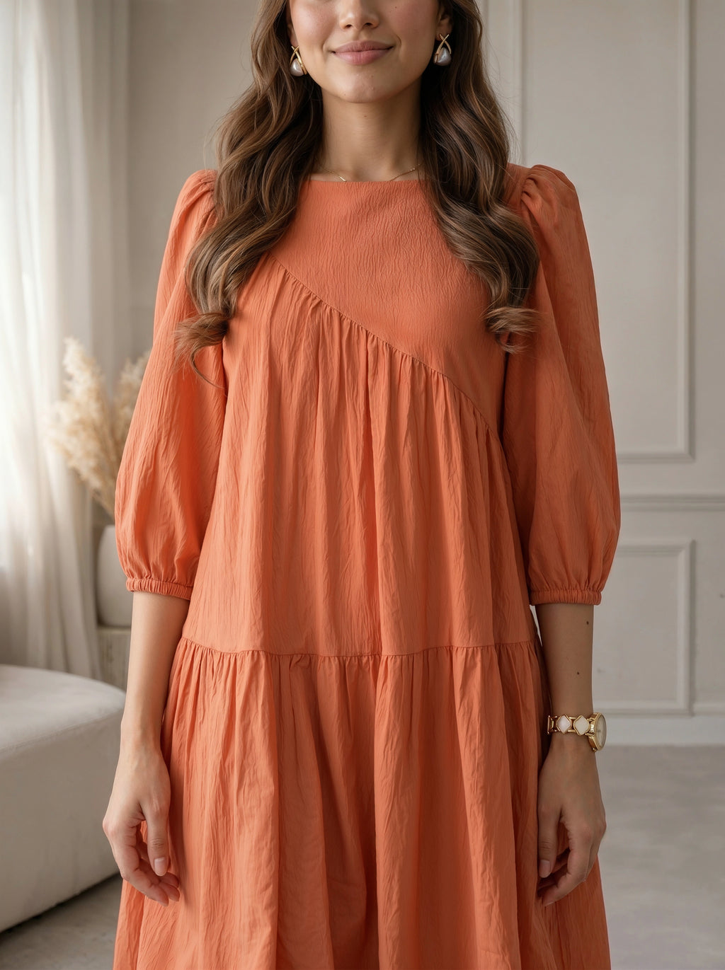 Woman wearing an orange dress in a room with neutral decor