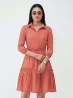 Woman wearing a coral dress with a white background