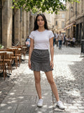 Woman standing on a street with tables and chairs in the background