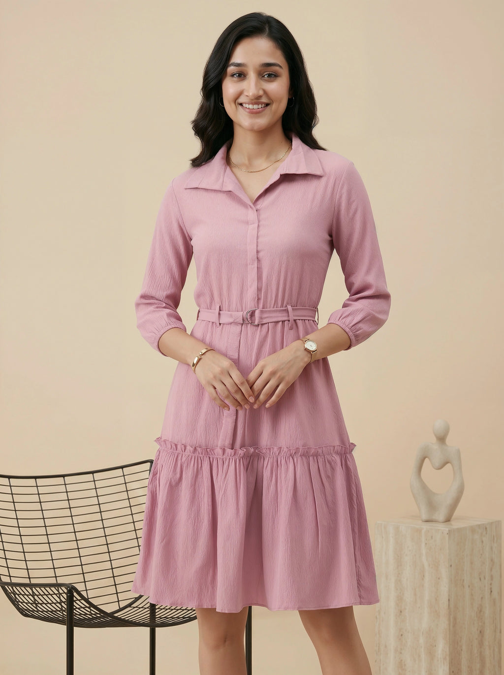 Woman wearing a pink dress standing against a beige background