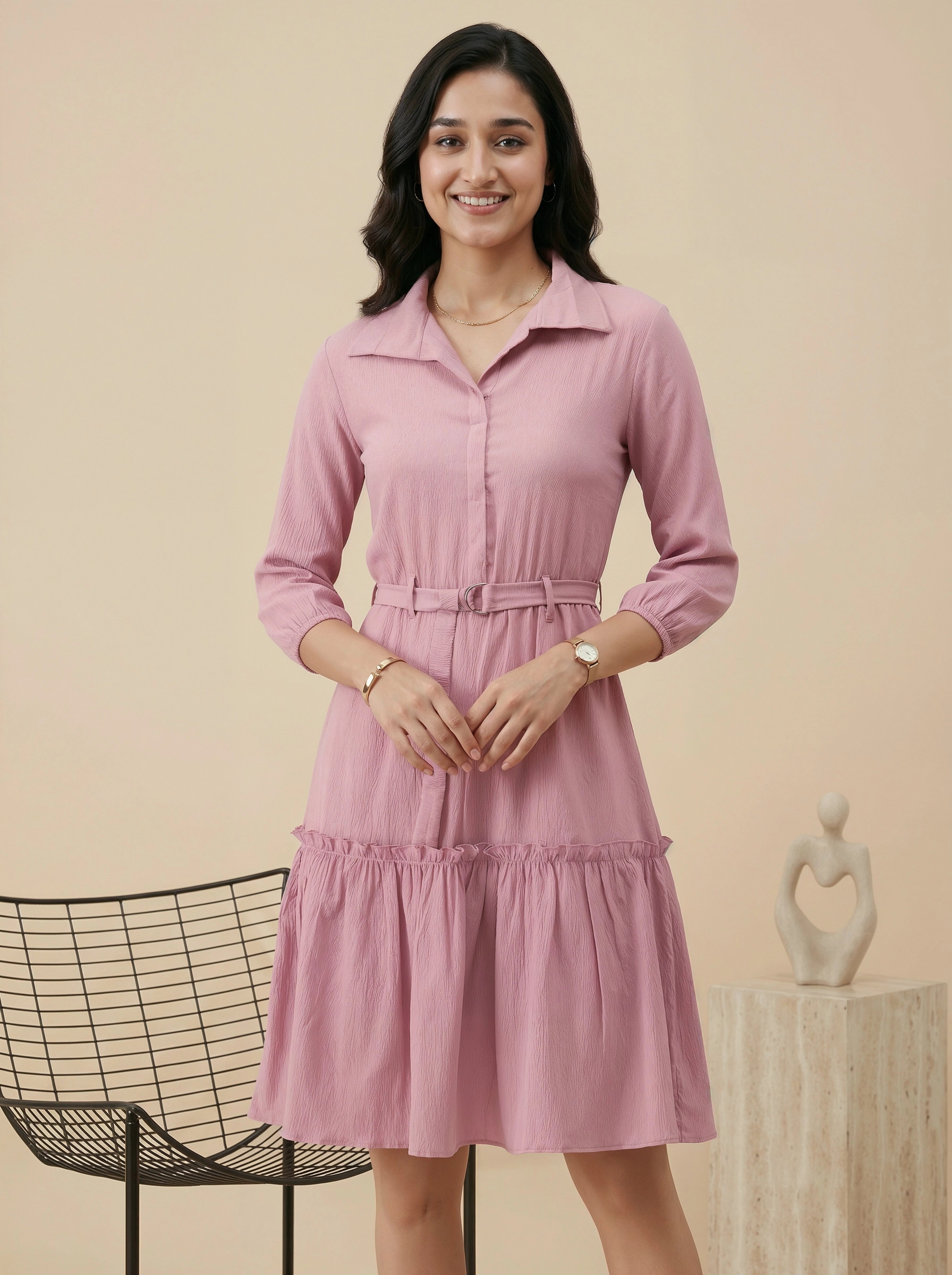 Woman wearing a pink dress standing against a beige background