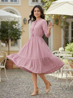 Woman in a pink dress standing outdoors on a patio