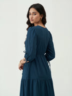 Woman wearing a teal dress on a white background