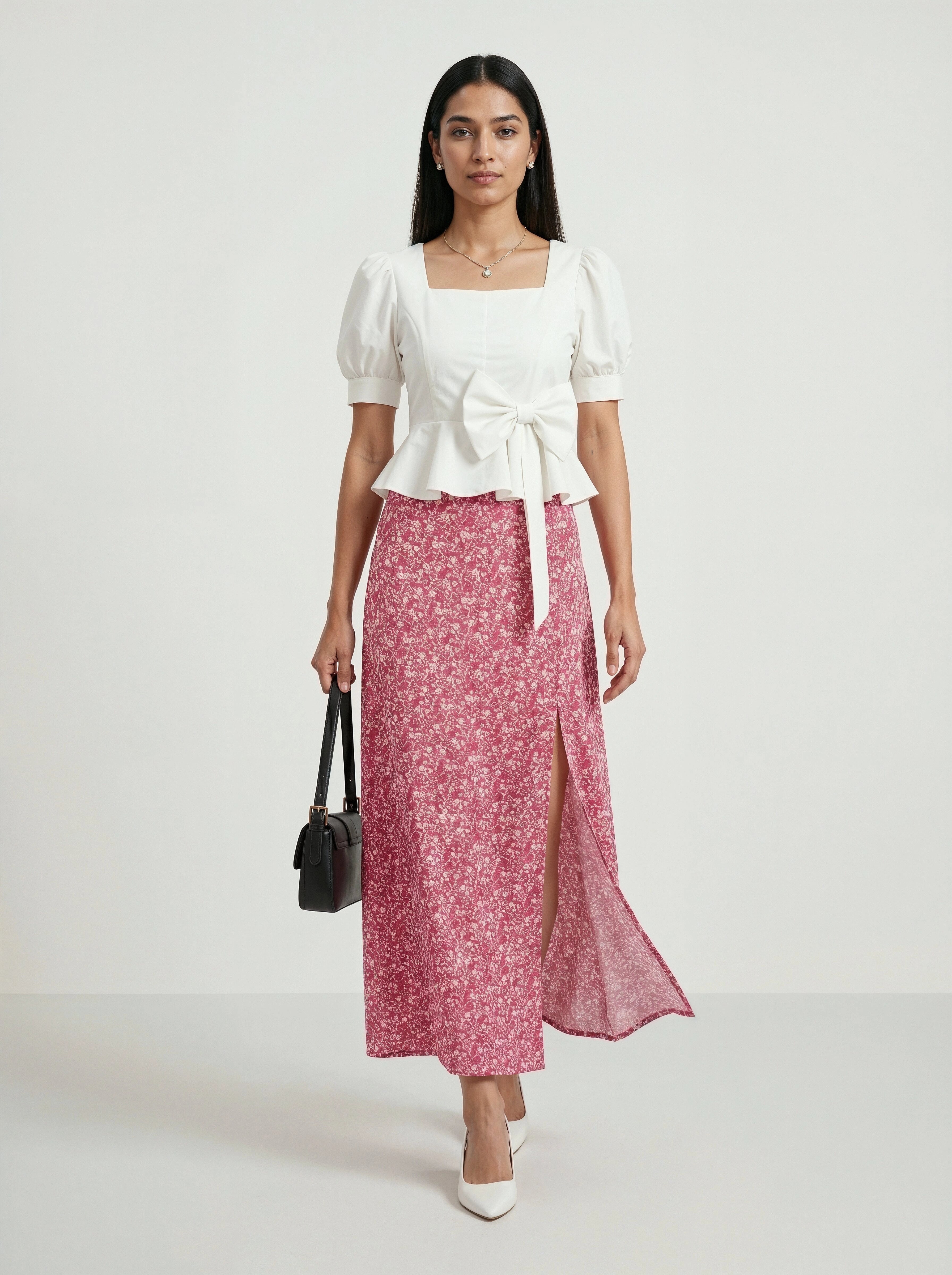Woman wearing a white top and pink floral skirt on a white background