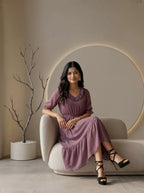 Woman wearing a plum colored tiered dress with black heels