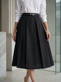 Person wearing a black skirt and white shirt in an indoor setting
