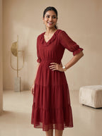 Woman wearing a red dress in a neutral-colored room