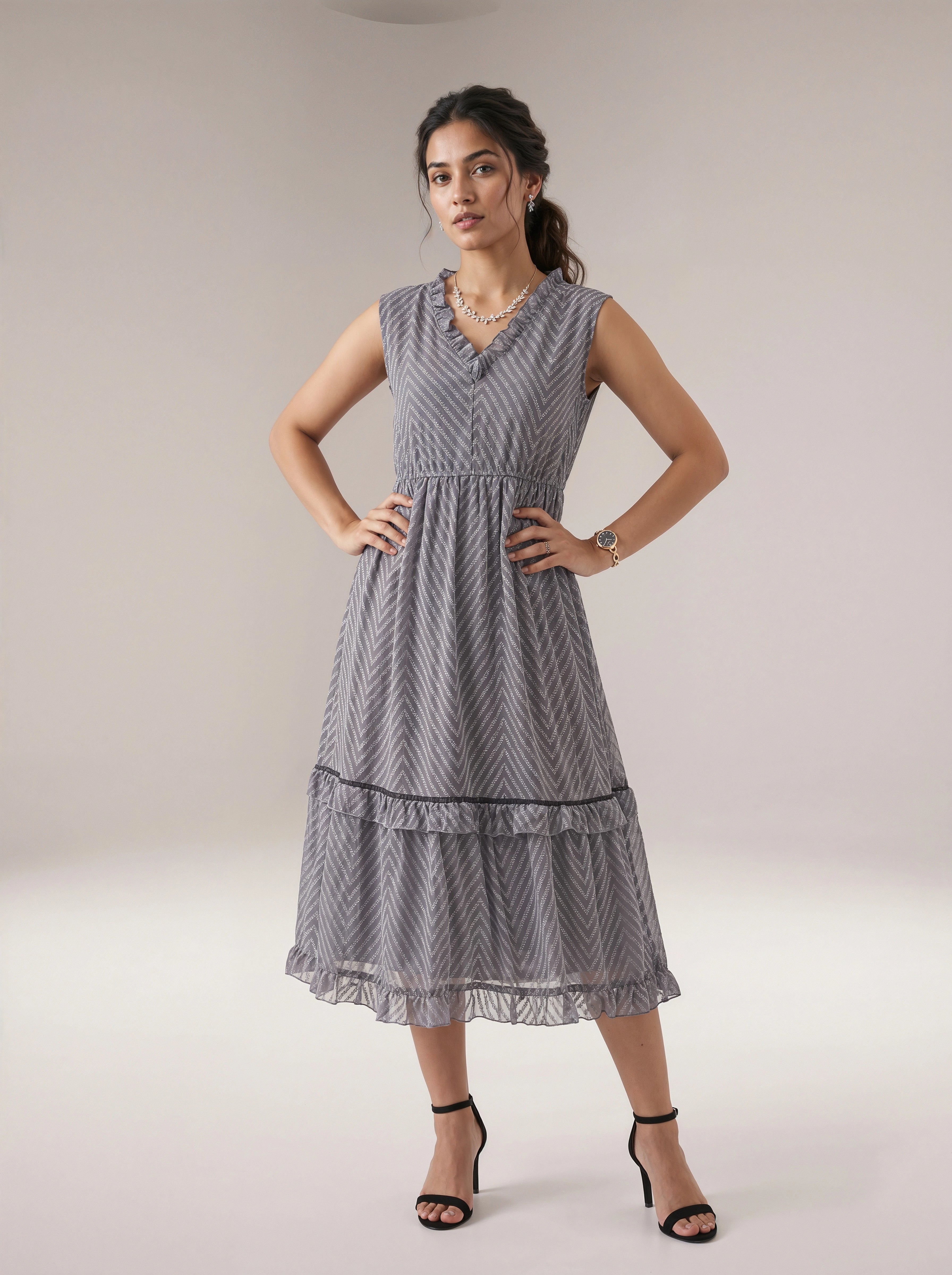 Woman wearing a sleeveless, patterned dress against a plain background