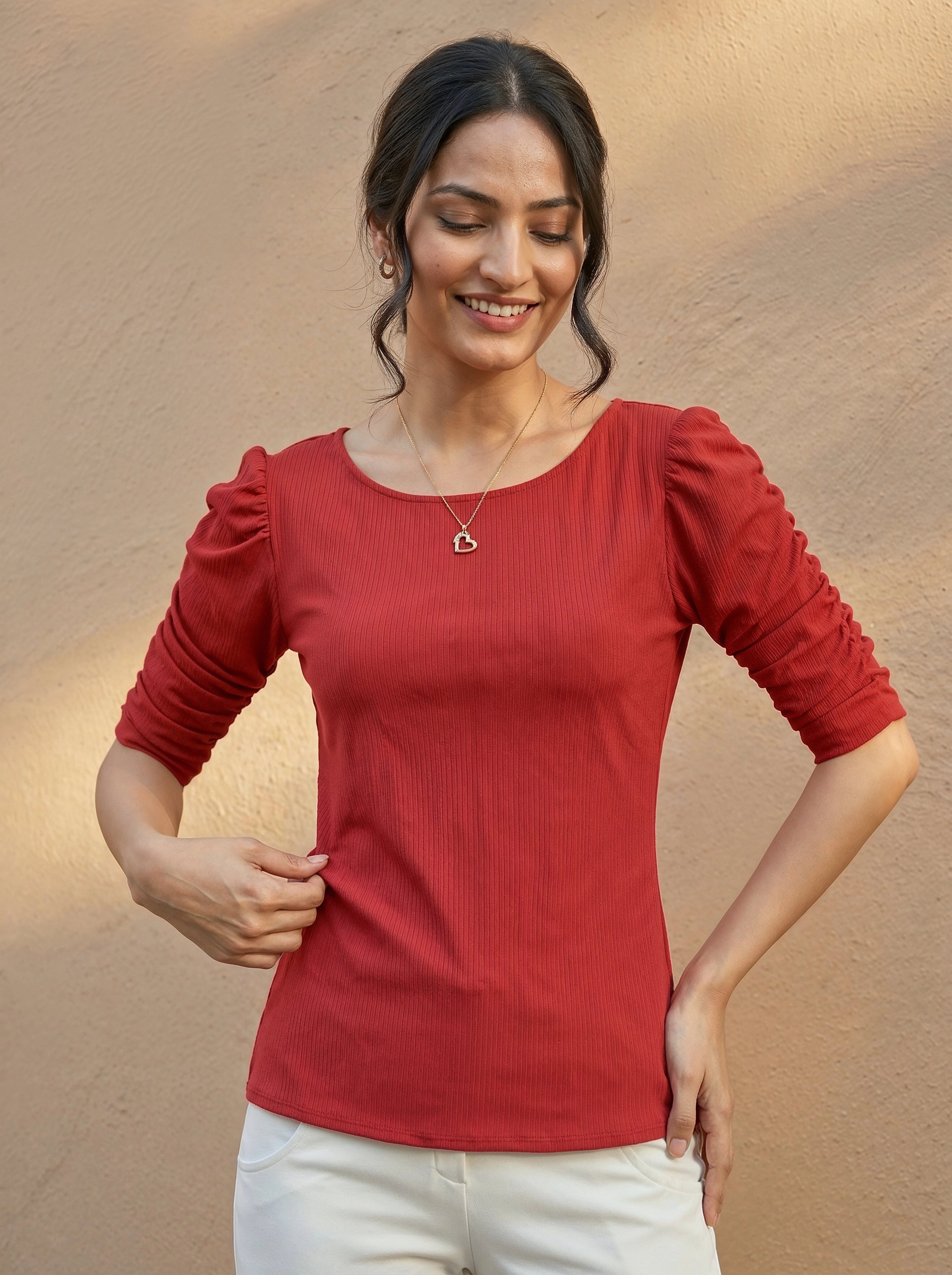 Woman wearing a red top with a neutral background