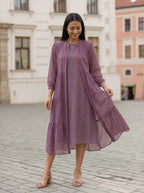Woman wearing a purple dress with a matching jacket in an urban setting
