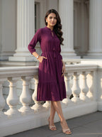 Woman in a purple dress standing in front of classical architecture