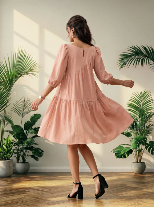 Woman in a pink dress standing in a room with plants