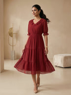 Woman wearing a red dress in a neutral-colored room