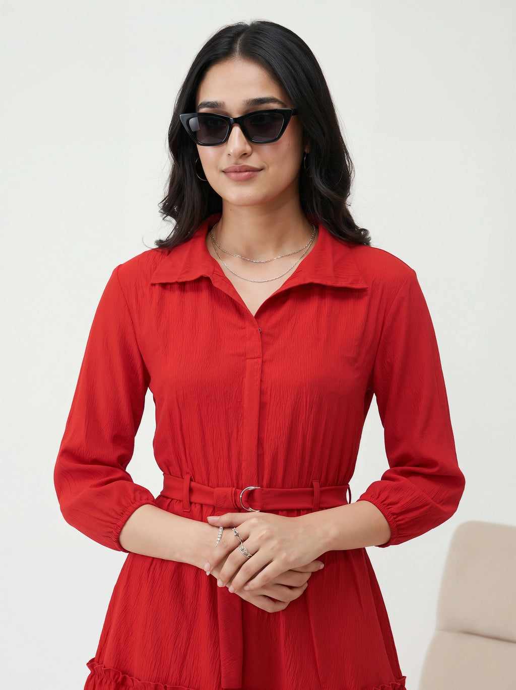 Woman wearing a red dress with sunglasses on a white background