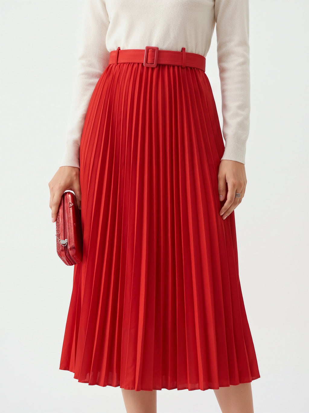 Red pleated skirt worn with a white top on a plain background