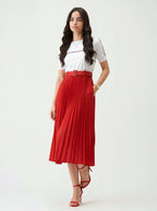 Woman wearing a white top and red pleated skirt on a white background