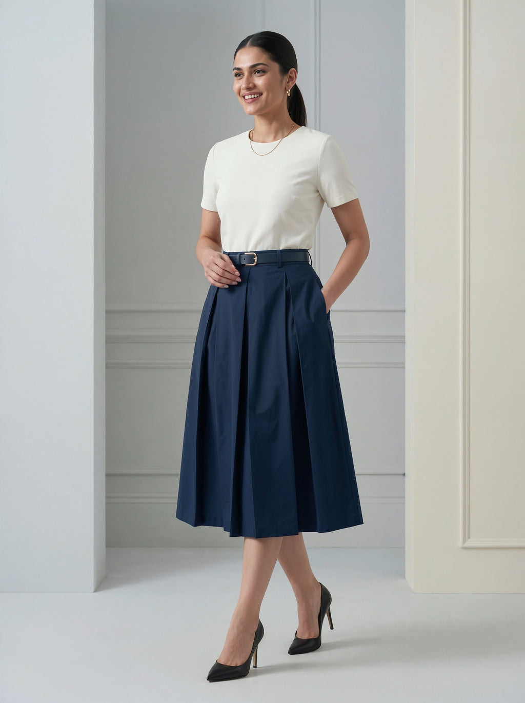 Woman wearing a white top and navy blue skirt in an indoor setting