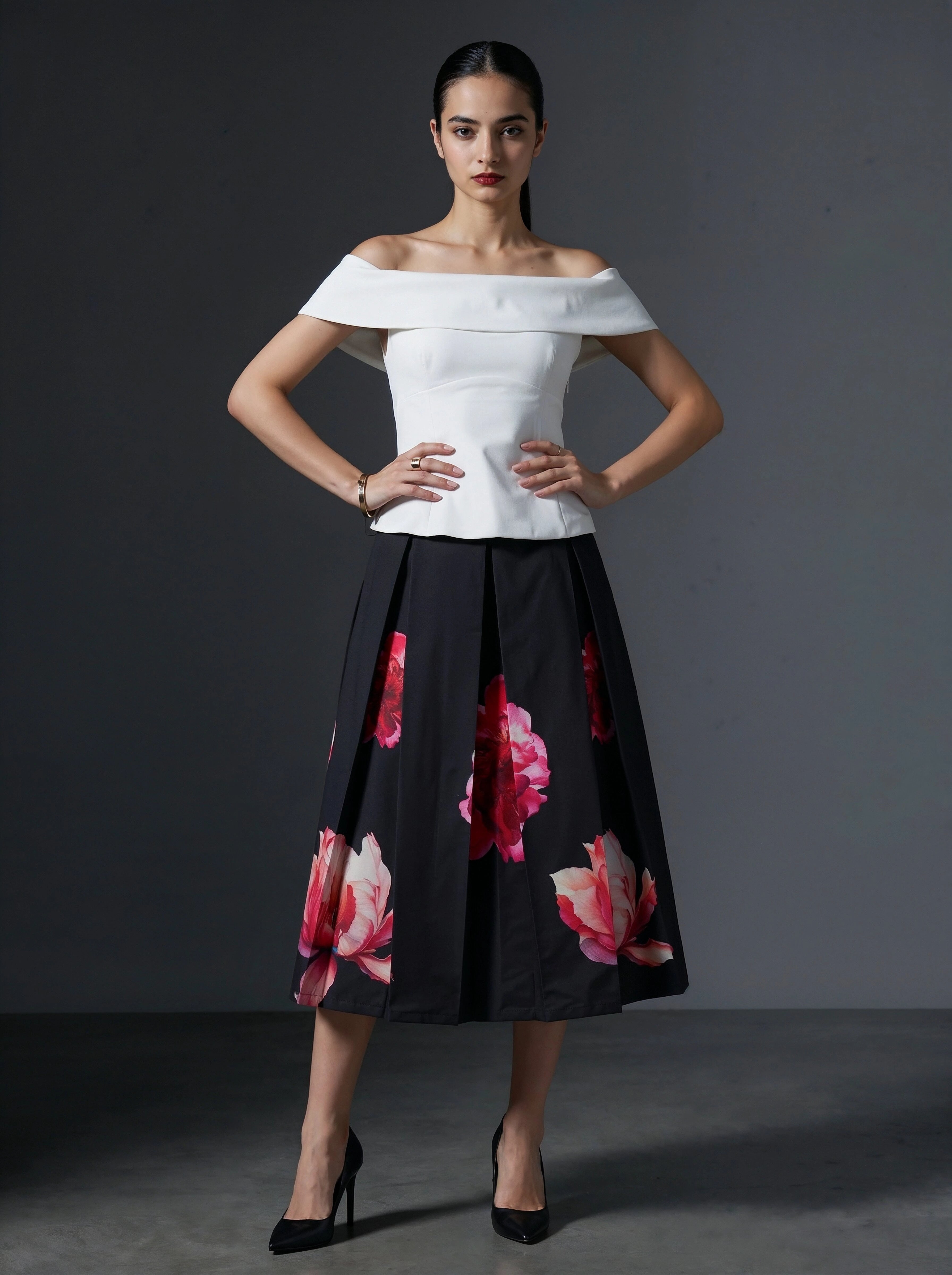 Woman wearing a white off-shoulder top and black floral skirt against a gray background
