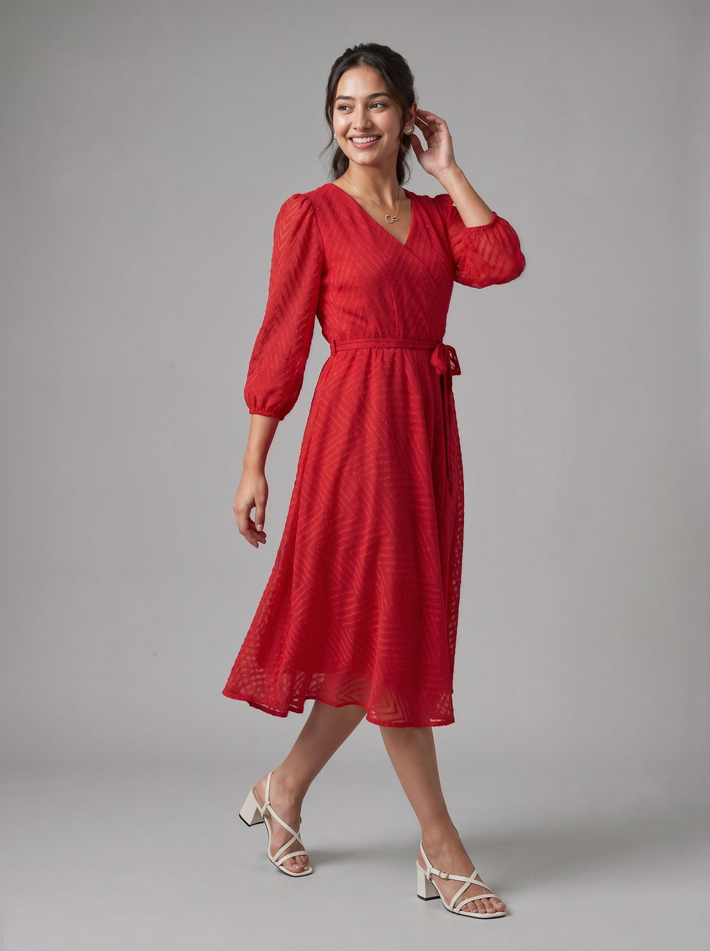 Woman wearing a red dress with puff sleeves against a gray background
