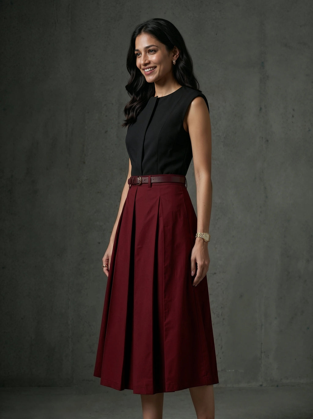 Woman wearing a black top and red skirt against a dark background