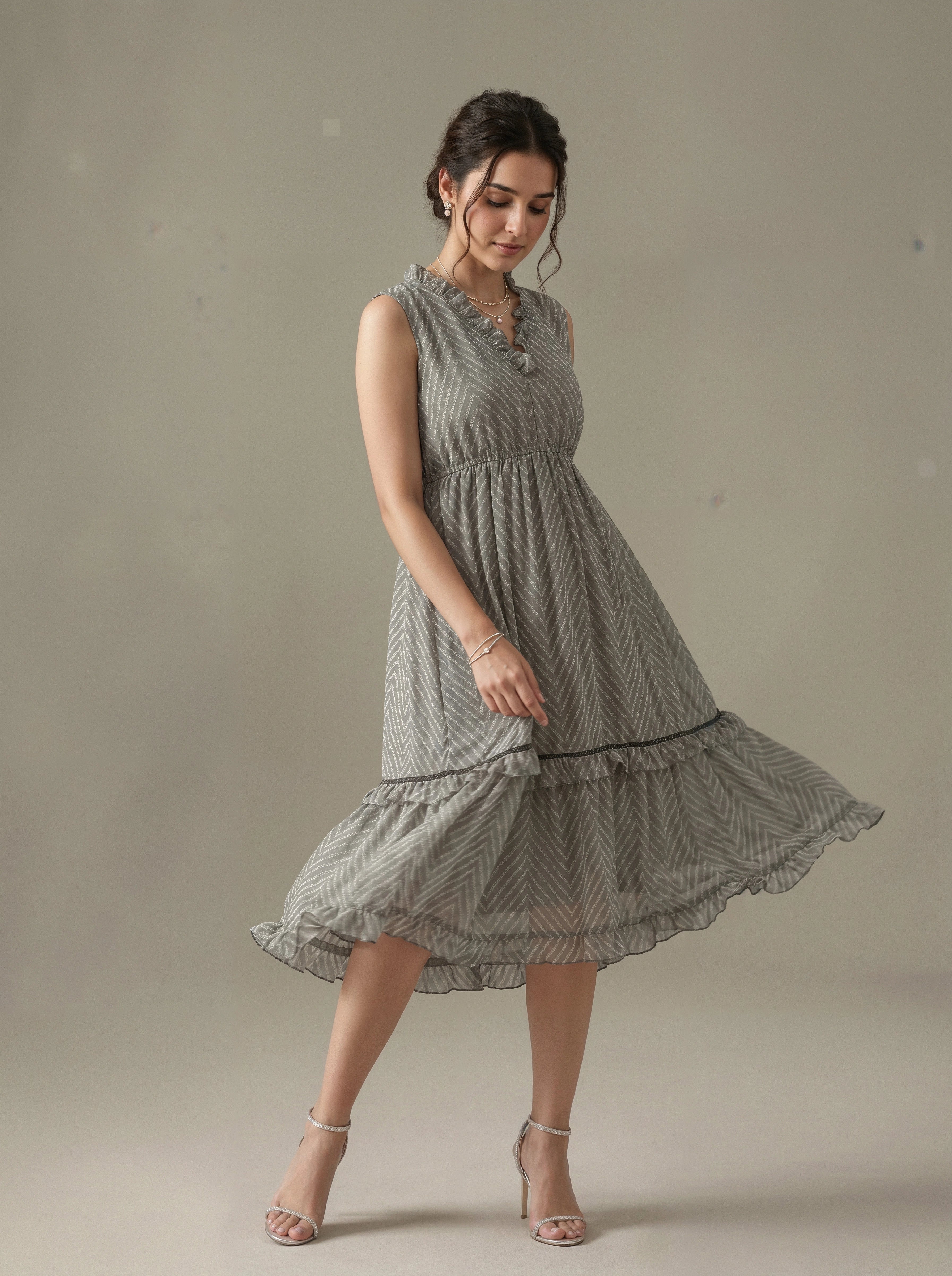Woman wearing a sleeveless, patterned dress against a neutral background