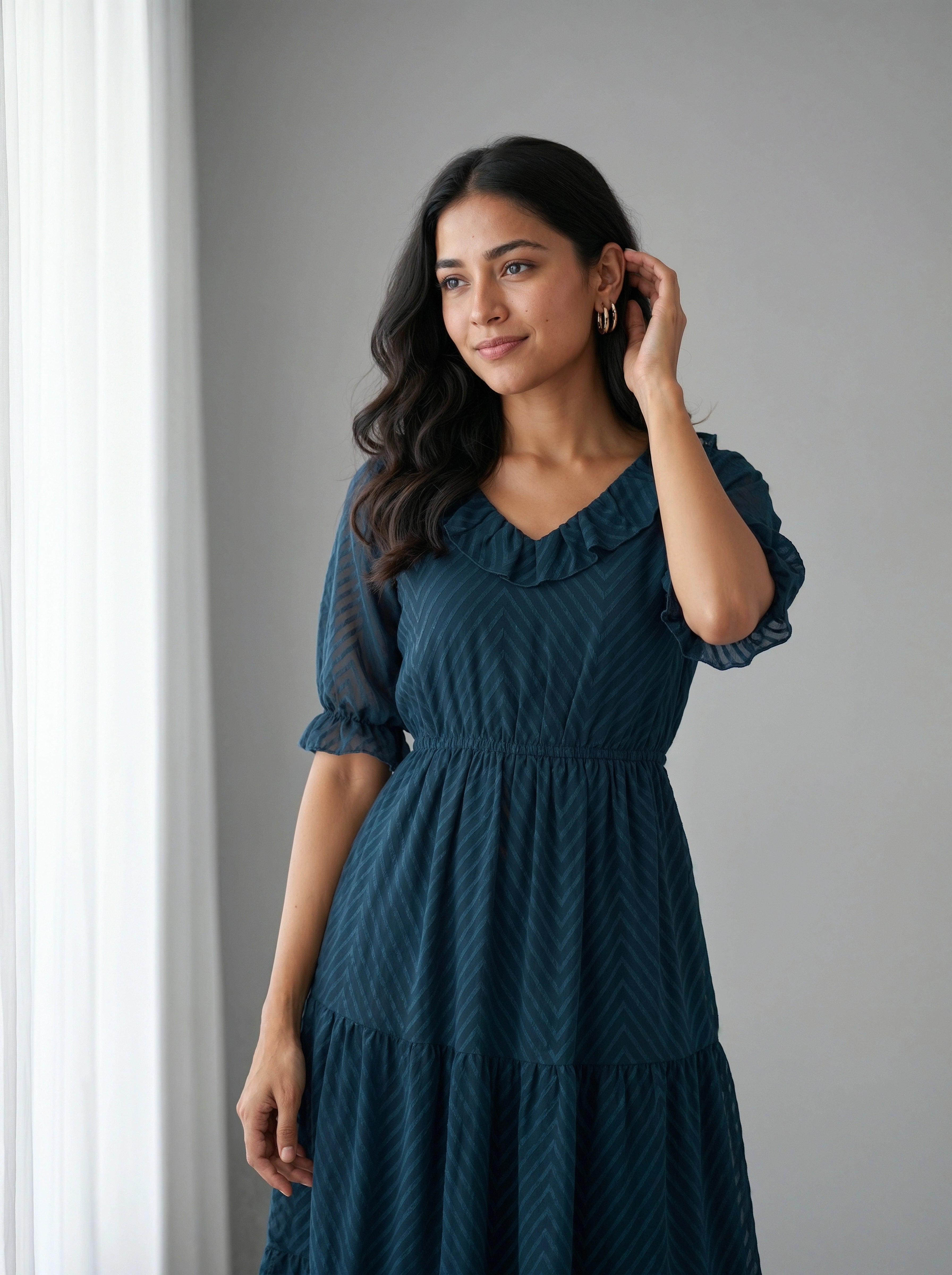 Woman wearing a blue dress against a gray background