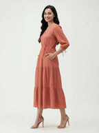 Woman wearing a rust-colored dress on a white background