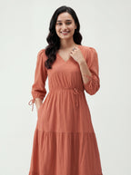 Woman wearing a rust-colored dress on a white background