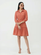 Woman wearing a coral dress on a white background