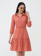 Woman wearing a coral dress with a white background