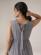 Woman wearing a gray patterned dress with a neutral background
