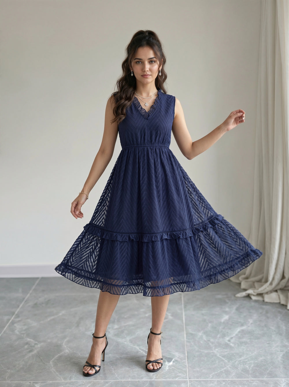 Woman wearing a navy blue dress in a room with a neutral background