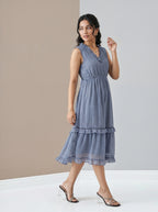 Woman wearing a blue dress standing against a neutral background